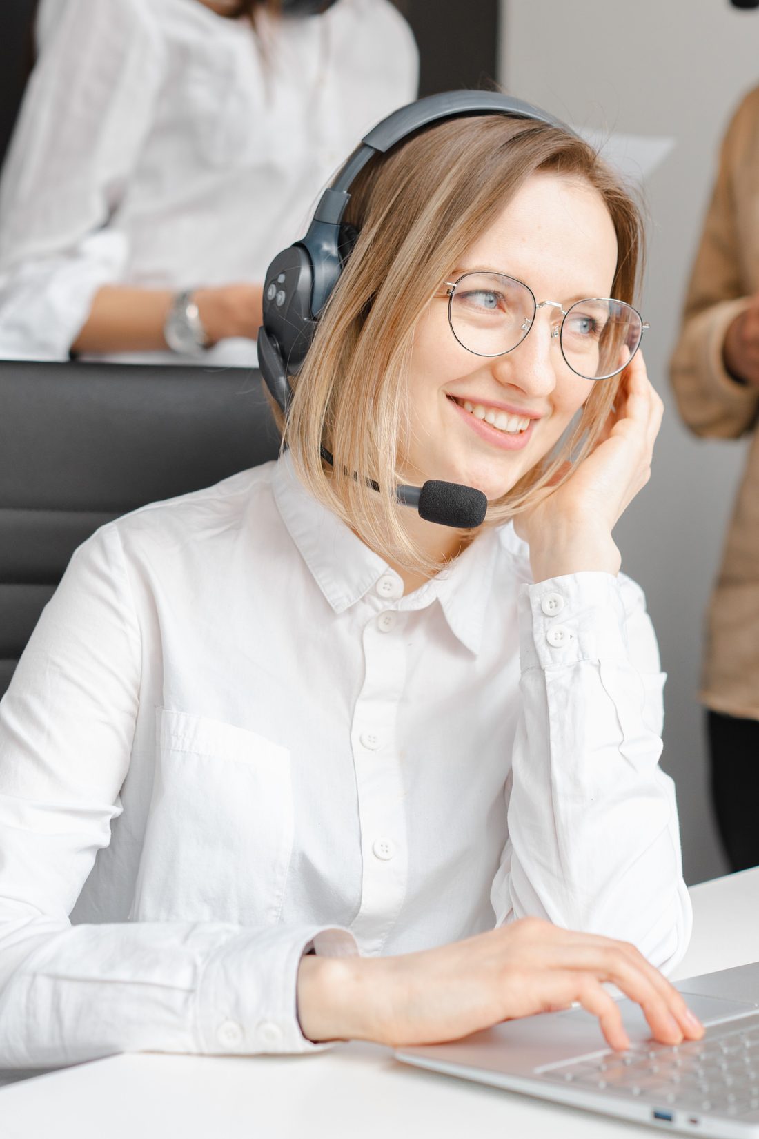 An Interconnect agent on a headset, mid-call at her workstation